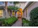 Inviting front entrance featuring a red door with glass panes and a brick pathway lined with manicured greenery at 7665 Portstewart Dr, Lakewood Ranch, FL 34202