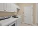 Bright laundry room features white cabinets and modern washer and dryer for convenient home chores at 7665 Portstewart Dr, Lakewood Ranch, FL 34202