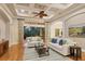 Bright living room featuring hardwood floors, a coffered ceiling, comfortable seating, and access to the outdoor patio at 7665 Portstewart Dr, Lakewood Ranch, FL 34202