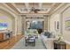 Cozy living room featuring hardwood floors, a coffered ceiling, comfortable seating, and sliding glass doors to the patio at 7665 Portstewart Dr, Lakewood Ranch, FL 34202