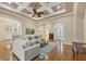 Elegant living room featuring hardwood floors, a coffered ceiling, comfortable seating, and an open layout at 7665 Portstewart Dr, Lakewood Ranch, FL 34202