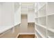 Spacious walk-in closet with built-in shelving units and wooden floors at 7665 Portstewart Dr, Lakewood Ranch, FL 34202