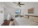 Bright bedroom with a private balcony, featuring a ceiling fan, a work desk, and a cozy rug at 800 N Tamiami Trl # 509, Sarasota, FL 34236