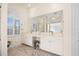 Bright bathroom with double vanity, ample cabinet space, and an arched window with shutters at 803 Coral Bean Cv, Venice, FL 34293