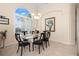 Bright dining room with natural lighting, decorative chandelier, and seating for six guests at 803 Coral Bean Cv, Venice, FL 34293