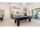 Open game room features a pool table, tile flooring, and views to the outside at 803 Coral Bean Cv, Venice, FL 34293