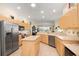 Spacious kitchen with stainless steel appliances, an island, and light wood cabinets at 803 Coral Bean Cv, Venice, FL 34293