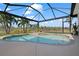 Screened-in pool with a relaxing atmosphere and views of the water and lush greenery at 803 Coral Bean Cv, Venice, FL 34293