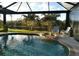 Enclosed outdoor pool with palm trees, water feature, and scenic views of the surrounding landscape at 803 Coral Bean Cv, Venice, FL 34293