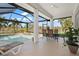 Screened patio with a pool overlooking a tranquil lake, perfect for outdoor dining and relaxation at 803 Coral Bean Cv, Venice, FL 34293