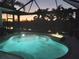 Tranquil swimming pool illuminated at twilight, creating a serene backyard oasis at 803 Coral Bean Cv, Venice, FL 34293