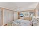 Bright bedroom with large closet, plantation shutters, and tropical bedding at 8140 Terrace Garden N Dr # 103, St Petersburg, FL 33709