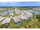 A serene aerial view showcasing a residential area with lakeside homes, screened pools, and lush landscaping at 8364 Sea Glass Ct, Sarasota, FL 34240