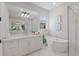 Bright bathroom features a soaking tub, walk-in shower with marble-look tile, and double sink vanity with ample counter space at 8364 Sea Glass Ct, Sarasota, FL 34240