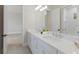 Bright bathroom featuring a long double vanity with sinks and a mirror, with an open door to another room at 8364 Sea Glass Ct, Sarasota, FL 34240