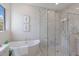 Bathroom featuring a soaking tub, a large glass shower with tiled walls, and a window letting in natural light at 8364 Sea Glass Ct, Sarasota, FL 34240