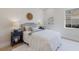 Bright bedroom with a neutral color palette features a bed with accent pillows, side tables, and a large window at 8364 Sea Glass Ct, Sarasota, FL 34240