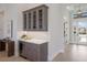 Hallway features a wet bar with quartz countertops and glass door access to the home's exterior at 8364 Sea Glass Ct, Sarasota, FL 34240