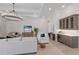 Bright living room features a stylish chandelier, comfortable white sofas, and a built-in bar area at 8364 Sea Glass Ct, Sarasota, FL 34240