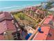 Aerial view of beachfront condos with red roofs, landscaping, and proximity to the ocean and beach at 8710 Midnight Pass Rd # 501B, Sarasota, FL 34242