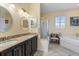 Bright bathroom featuring dual sinks, granite countertops, and separate tub and shower at 9408 69Th E Ave, Palmetto, FL 34221