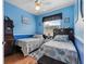 Cozy bedroom with two twin beds, blue walls, and natural light from the window at 9408 69Th E Ave, Palmetto, FL 34221