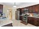 Modern kitchen with stainless steel appliances, dark wood cabinets, and granite countertops at 9408 69Th E Ave, Palmetto, FL 34221