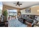 Comfortable living room with a large sectional sofa, ceiling fan, area rug and a sliding glass door to the patio at 9408 69Th E Ave, Palmetto, FL 34221