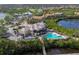 Panoramic aerial view of a community clubhouse, pool, surrounding homes, and picturesque waterways at 9460 Discovery Ter # 202D, Bradenton, FL 34212