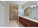 Beautiful bathroom with double sinks, granite countertop, and walk-in shower with stone accents at 9460 Discovery Ter # 202D, Bradenton, FL 34212