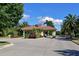 Beautiful entrance to the community with a red tile roof and mature trees at 9460 Discovery Ter # 202D, Bradenton, FL 34212