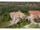Aerial view showcasing the home's tile roof, lush landscaping, and brick driveway at 9460 Discovery Ter # 202D, Bradenton, FL 34212