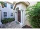 Charming front entrance with brick walkway, decorative welcome mat, and tropical landscaping at 9460 Discovery Ter # 202D, Bradenton, FL 34212