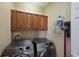 Well-equipped laundry room with wood cabinets and modern washer and dryer units at 9460 Discovery Ter # 202D, Bradenton, FL 34212