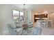 Comfortable sitting area leading to the kitchen with large windows and modern lighting at 9460 Discovery Ter # 202D, Bradenton, FL 34212