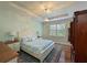 Relaxing bedroom with a king-size bed, soft colors, and natural light streaming through plantation shutters at 9460 Discovery Ter # 202D, Bradenton, FL 34212
