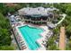 Aerial view showcasing a community pool with lounge chairs, tables, lush landscaping, and nearby boat parking at 9460 Discovery Ter # 202D, Bradenton, FL 34212