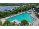 Aerial view of a community pool surrounded by lounge chairs, landscaping, and a scenic waterfront view at 9460 Discovery Ter # 202D, Bradenton, FL 34212