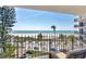 Balcony view captures palm trees, white sand, ocean, and street below creating a relaxing and scenic outdoor space at 101 Benjamin Franklin Dr # 63, Sarasota, FL 34236