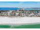 Panoramic view of a white sand beach, turquoise water, and nearby buildings on a sunny day at 101 Benjamin Franklin Dr # 63, Sarasota, FL 34236