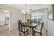 Dining room with table, chairs, chandelier, and view to living area and ocean at 101 Benjamin Franklin Dr # 63, Sarasota, FL 34236