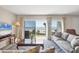 Serene living room with comfortable seating, a wooden table, and sliding doors revealing breathtaking ocean views at 101 Benjamin Franklin Dr # 63, Sarasota, FL 34236