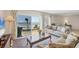 Bright living room with balcony access offers ocean views, comfortable seating, and natural light at 101 Benjamin Franklin Dr # 63, Sarasota, FL 34236