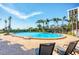 Inviting community pool surrounded by palm trees and lounge chairs for relaxation at 101 Benjamin Franklin Dr # 63, Sarasota, FL 34236