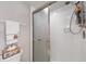 Shower with glass doors, white tiling, toiletries, and a mounted showerhead providing a clean and functional bathroom feature at 101 Benjamin Franklin Dr # 63, Sarasota, FL 34236