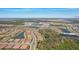 Expansive aerial view showcasing a community with multiple homes surrounding lakes, nestled amidst natural green spaces, and roadways at 10802 Seasons Way, Palmetto, FL 34221