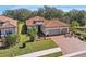 Stunning aerial view of a well-maintained home with lush landscaping, a brick driveway, and a serene neighborhood setting at 10802 Seasons Way, Palmetto, FL 34221