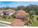 Stunning aerial view of a well-maintained home with lush landscaping, a brick driveway, and a serene neighborhood setting at 10802 Seasons Way, Palmetto, FL 34221