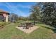 Backyard patio area featuring brick pavers, comfortable seating, and serene views of the surrounding greenery at 10802 Seasons Way, Palmetto, FL 34221