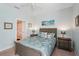 Comfortable bedroom with coastal decor, natural lighting, matching nightstands, and a plush queen-sized bed with decorative pillows at 10802 Seasons Way, Palmetto, FL 34221